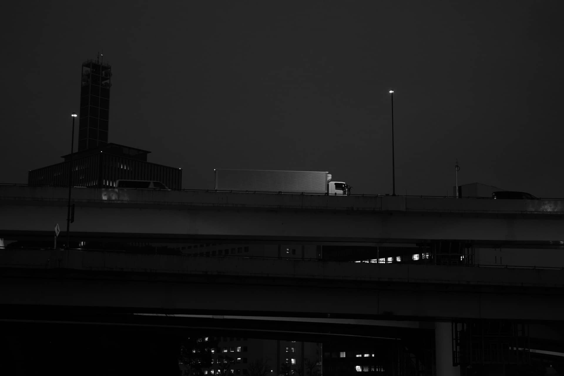 Cargo truck crossing a highway overpass at night